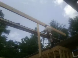 Carpenter setting a ridge beam over a new addition frame — Ice Dam Removal by Roofing Brothers in Fairbanks