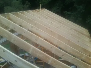 New roof rafters set over an addition before sheathing in Fairbanks
