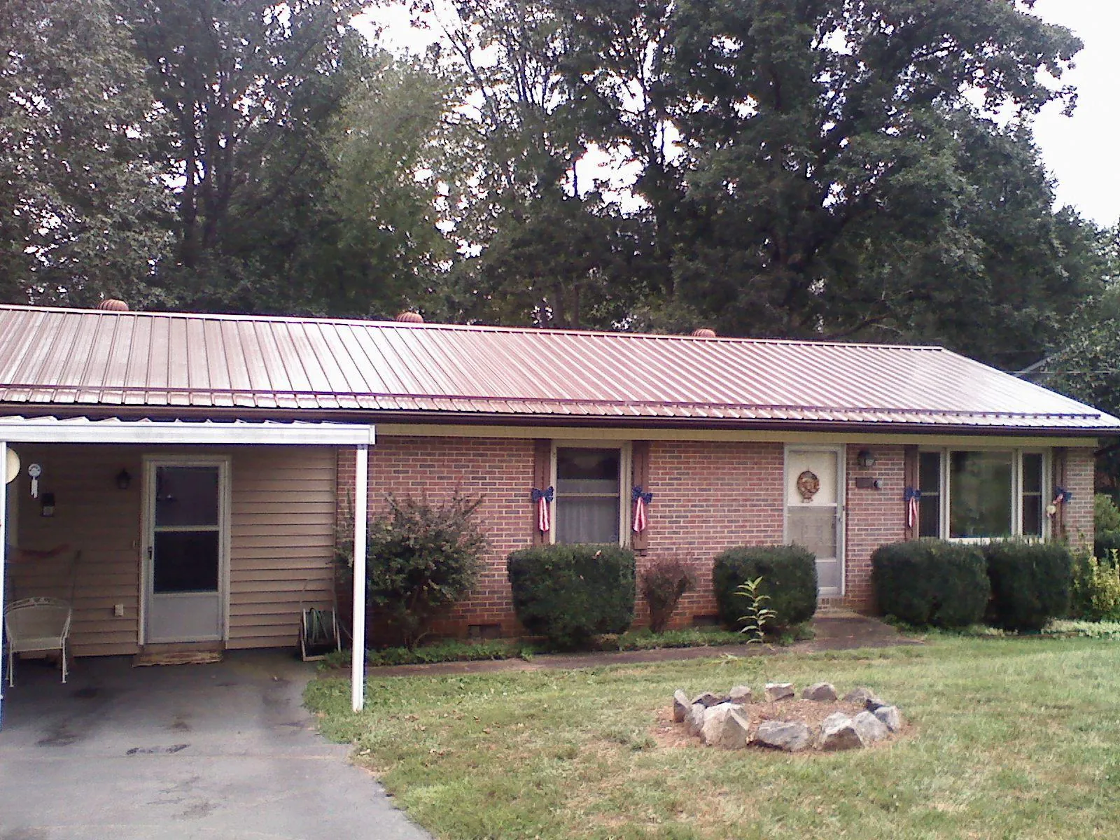 Bronze metal roof and carport on a brick ranch home — Roof Repair work by our crew in Fairbanks